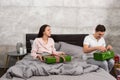 Young happy couple in pajamas unpacking their presents while sit Royalty Free Stock Photo