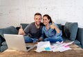 Young happy young couple paying bills with laptop feeling fortunate and lucky off debts Royalty Free Stock Photo