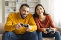 Young Happy Couple Playing Video Games With Joysticks At Home Royalty Free Stock Photo