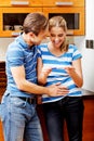 Young happy couple with pregnancy test standing in kitchen Royalty Free Stock Photo