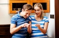 Young happy couple with pregnancy test standing in kitchen Royalty Free Stock Photo