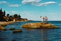 Young happy couple relaxing on the rock on the beach, Black Sea, Odessa, Ukraine, place for text set Royalty Free Stock Photo