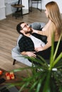 Young happy couple resting on a sofa at home gently touching each other Royalty Free Stock Photo