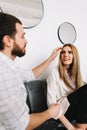 Young happy couple resting on a sofa at home, gently touching each other Royalty Free Stock Photo