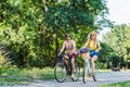 young happy couple riding retro bicycles in park