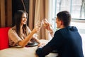 Young happy couple romantic date drink glass of white wine at restaurant, celebrating valentine day Royalty Free Stock Photo