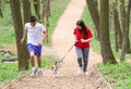 Young happy couple running with a dog Royalty Free Stock Photo