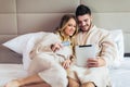 Happy couple shopping online in luxury hotel room Royalty Free Stock Photo