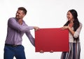 Young happy couple showing presentation pointing placard