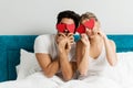 Young happy couple sitting on the bed, holding hearts Royalty Free Stock Photo