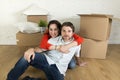 Young happy couple sitting on floor together celebrating moving in new flat house or apartment Royalty Free Stock Photo