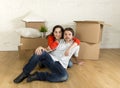 Young happy couple sitting on floor together celebrating moving in new flat house or apartment Royalty Free Stock Photo