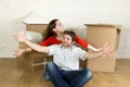 Young happy couple sitting on floor together celebrating moving in new flat house or apartment Royalty Free Stock Photo