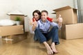 Young happy couple sitting on floor together celebrating moving in new flat house or apartment Royalty Free Stock Photo