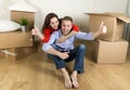 Young happy couple sitting on floor together celebrating moving in new flat house or apartment Royalty Free Stock Photo