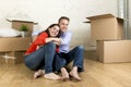 Young happy couple sitting on floor together celebrating moving in new flat house or apartment Royalty Free Stock Photo