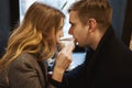 Young happy couple sitting over the window in cafe and drinking coffee from one cup. Royalty Free Stock Photo