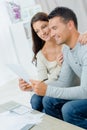 Young happy couple sitting on sofa calculating budget Royalty Free Stock Photo