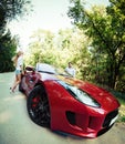 Young happy couple standing near red car Royalty Free Stock Photo