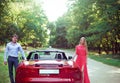 Young happy couple standing near red car Royalty Free Stock Photo