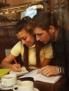 Young happy couple students in cafe, view through a window Royalty Free Stock Photo