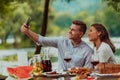 young happy couple taking selfie while having picnic french dinner party outdoor during summer holiday vacation near the Royalty Free Stock Photo