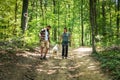 Young happy couple and their dog at hiking through the woods enjoying the sight. Two nature lovers in the mountain forest enjoy Royalty Free Stock Photo