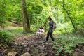 Young happy couple and their dog at hiking through the woods enjoying the sight. Two nature lovers in the mountain forest enjoy Royalty Free Stock Photo