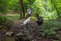 Young happy couple and their dog at hiking through the woods enjoying the sight. Two nature lovers in the mountain forest enjoy Royalty Free Stock Photo