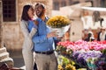 Young happy couple in their honeymoon in italy, toscana, europe. Man is buying a bucket of flowers for his girlfriend Royalty Free Stock Photo