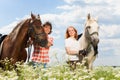 Young happy couple with their purebred horses Royalty Free Stock Photo