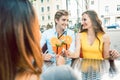 Happy couple toasting with their mutual female friend at a trendy restaurant