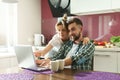 Happy couple using laptop in the kitchen at morning Royalty Free Stock Photo