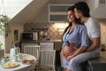 Husband and his pregnant wife on the kitchen during breakfast time. Royalty Free Stock Photo