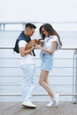 Young happy couple on walk with small dog on sea promenade Royalty Free Stock Photo