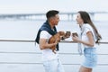 Young happy couple on walk with small dog on sea promenade Royalty Free Stock Photo