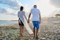 Young happy couple walking on the beach holding hands, back view. Royalty Free Stock Photo