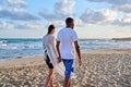 Young happy couple walking on the beach holding hands, back view. Royalty Free Stock Photo