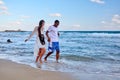 Young happy couple walking on the beach holding hands, copy space Royalty Free Stock Photo