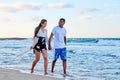 Young happy couple walking on the beach holding hands, copy space Royalty Free Stock Photo