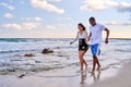 Young happy couple walking on the beach holding hands, copy space Royalty Free Stock Photo