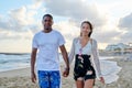 Young happy couple walking on the beach holding hands. Royalty Free Stock Photo