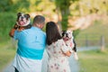 Young Happy Couple walking and carrying English Bulldogs