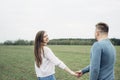 Young happy couple walking in the green field and enjoy each other. Holidays, vacation, love and friendship concept Royalty Free Stock Photo