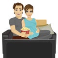 Young happy couple watching movie at home sitting with popcorn on sofa Royalty Free Stock Photo