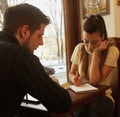 Young happy couples tudents in cafe, view through a window Royalty Free Stock Photo