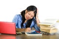 Young happy and cute Asian Chinese student girl smiling happy working and studying with texbooks and laptop computer sitting on Royalty Free Stock Photo