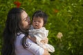 Young happy and cute Asian Chinese woman enjoying and playing with her baby girl daughter holding and kissing her smiling cheerful Royalty Free Stock Photo