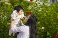 Young happy and cute Asian Chinese woman enjoying and playing with her baby girl daughter holding her raising up in her arms Royalty Free Stock Photo