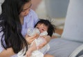 Young happy and cute Asian Chinese woman playing with daughter baby girl at holidays tropical resort swimming pool enjoying summer